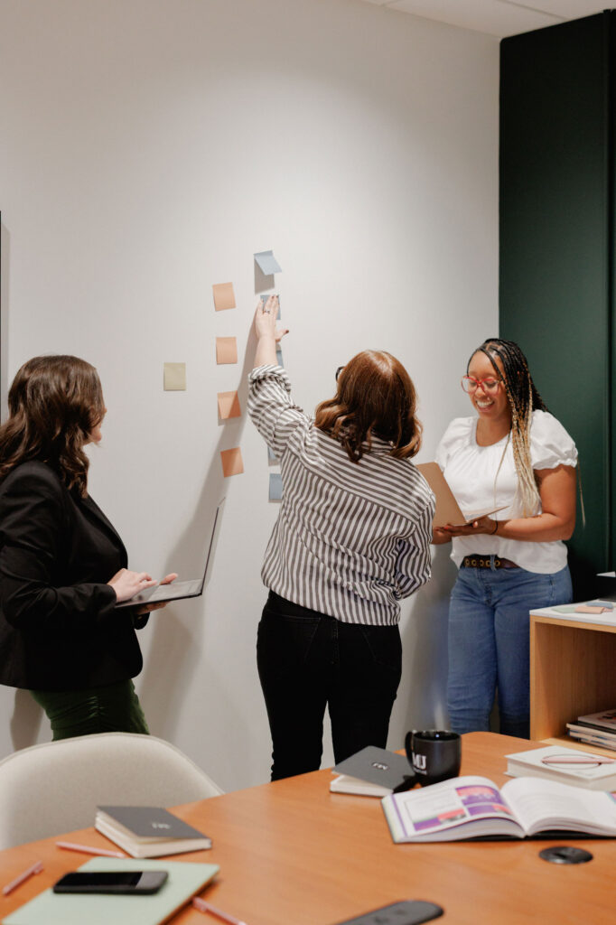 Charlotte web design team collaborating with sticky notes on wall.