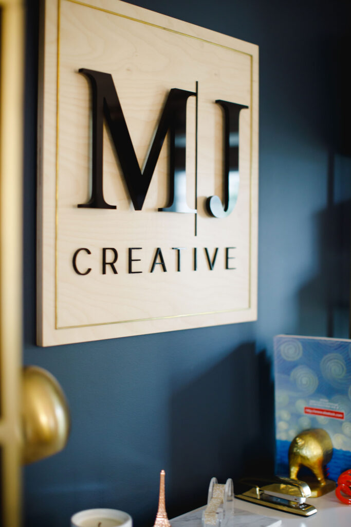MJ Creative sign on dark wall.