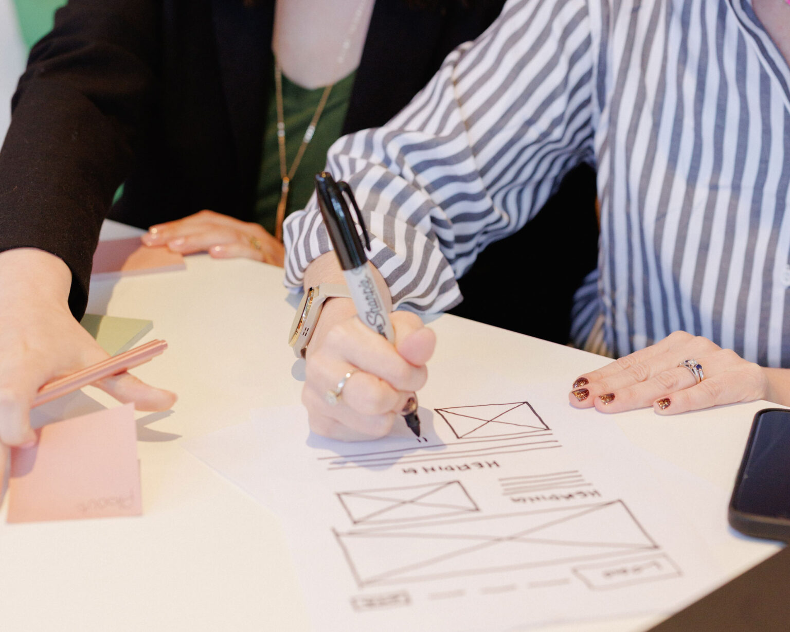 People collaborating on website design sketches.